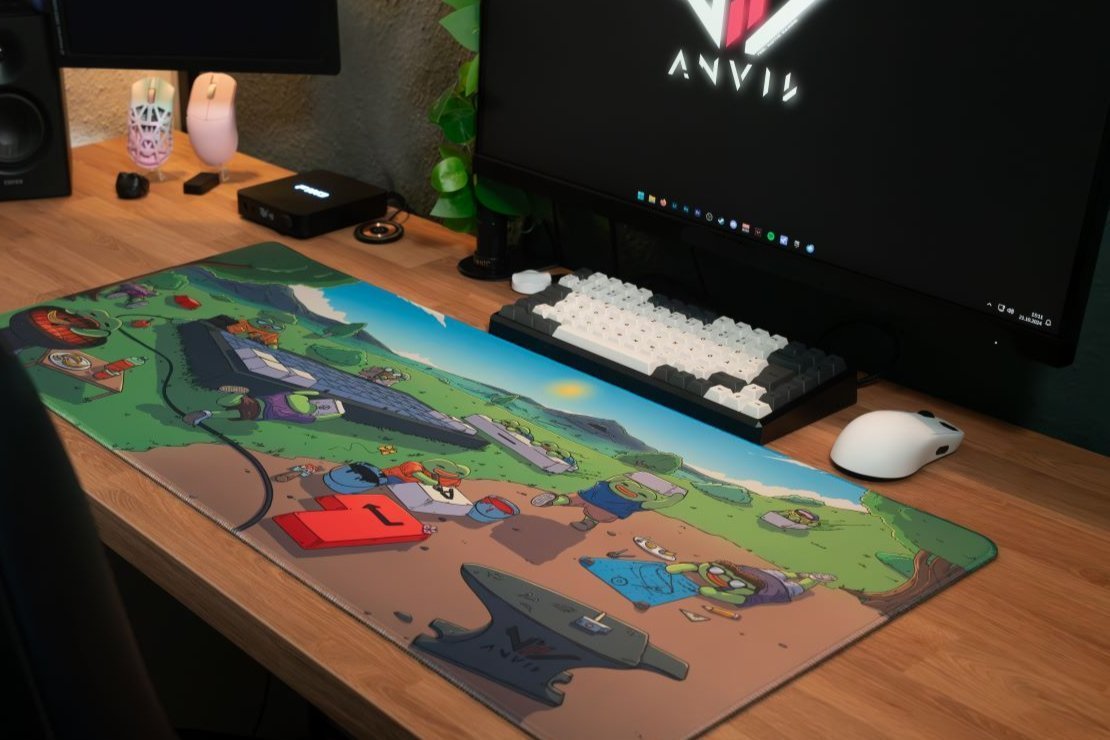 Deskmat Tinkerworld auf einem Schreibtisch vor einem Monitor mit ANVIL Logo